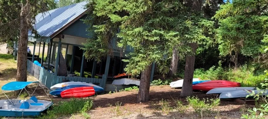 Canoes, kayaks and a pedal boat beside the cabin