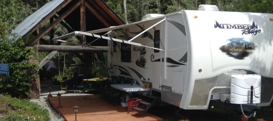 RV parked under a timber-frame shelter